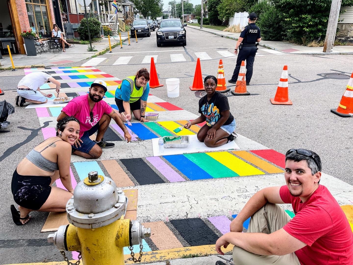 Volunteers painting Newport's first Pride crosswalk last year; catch Newport Pride's annual celebrations later this month